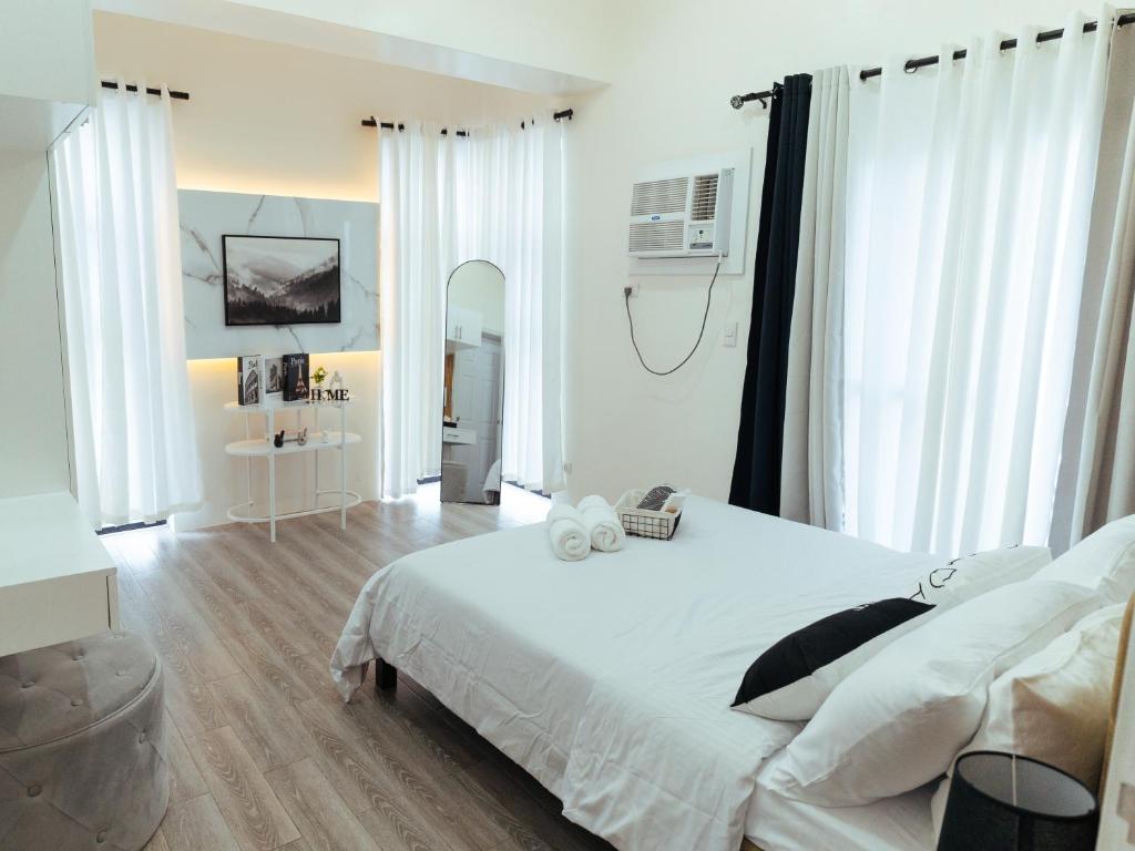 Schlafzimmer mit einem großen weißen Bett und weißen Vorhängen in der Unterkunft Hannah's Place in Davao City