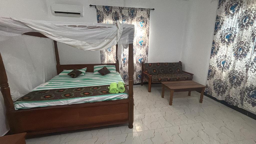 Un dormitorio con una cama y una silla y una ventana. en Nashipai house, en Nungwi
