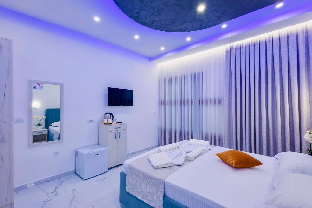 a white bedroom with a bed and a window at APART-HOTEL PRESiDENT 2 in Ulcinj