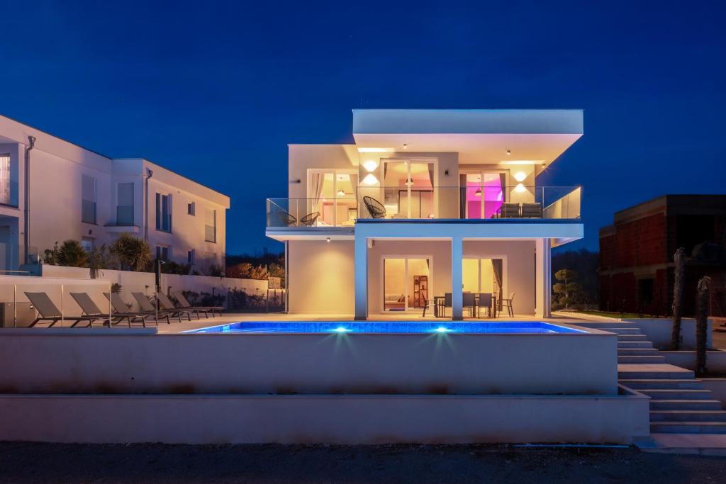 a villa with a swimming pool at night at Villa Neoma in Linardići