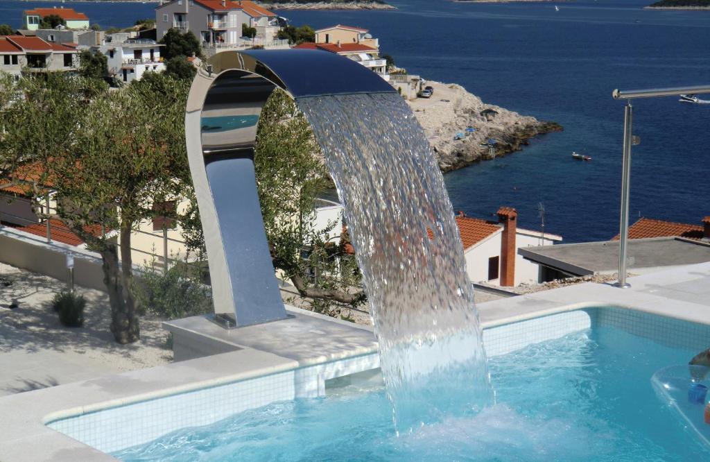 a fountain in a pool with a view of the ocean at Villa Gina in Sevid