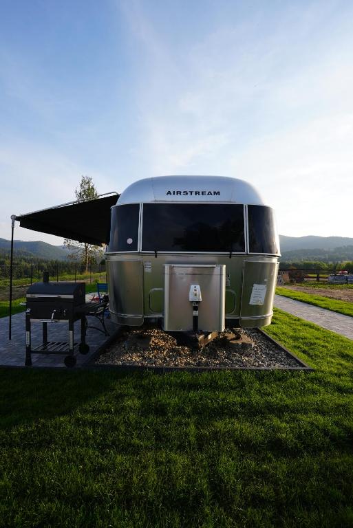 Una caravana verde y blanca estacionada junto a una mesa de picnic. en Bieszczadzki Airstream, en Wetlina