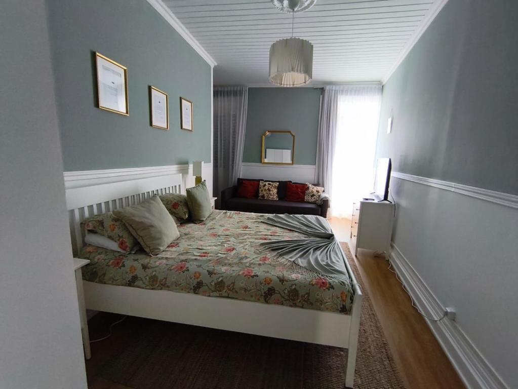 a small bedroom with a bed and a window at Cantinho da Cruz in Ponta Delgada