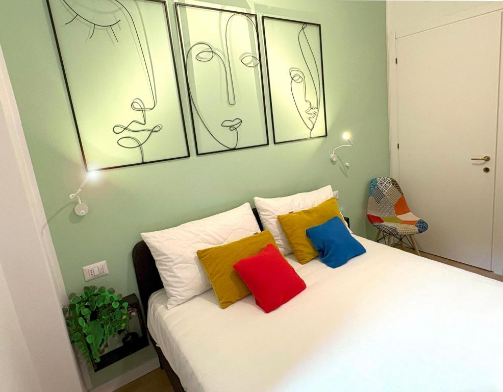 a bedroom with a bed with colorful pillows on it at Grande Cittadella Rooms in Genova
