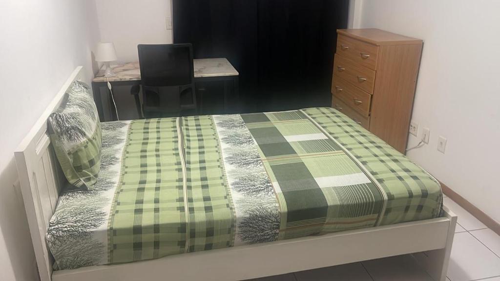 a bedroom with a bed with a desk and a chair at Condominio Nobless Angola Talatona in Luanda