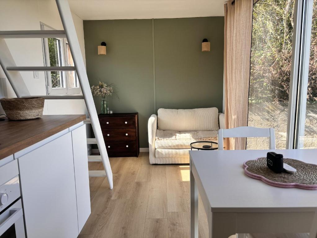 a kitchen with a staircase leading to a living room at Tiny House Cosy Climatisée in Saint-Sylvain-dʼAnjou