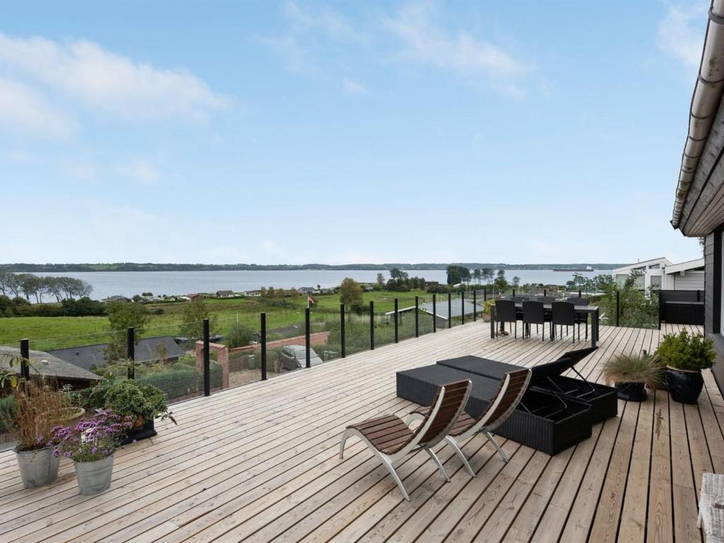 a wooden deck with a table and chairs on it at Holiday Home Karli - 330m to the fjord by Interhome in Aabenraa