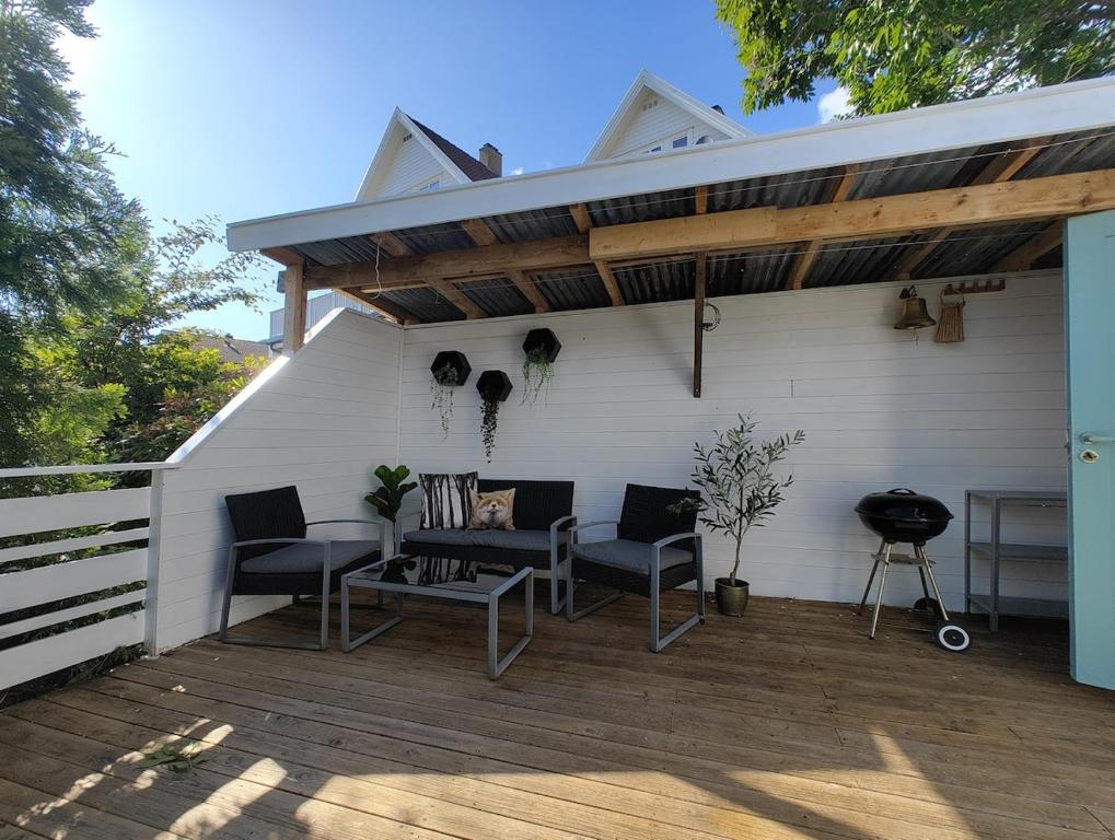 a patio with chairs and a table on a deck at Lillebu in Strand