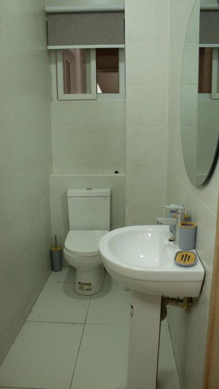 a white bathroom with a toilet and a sink at Haven property in Lagos