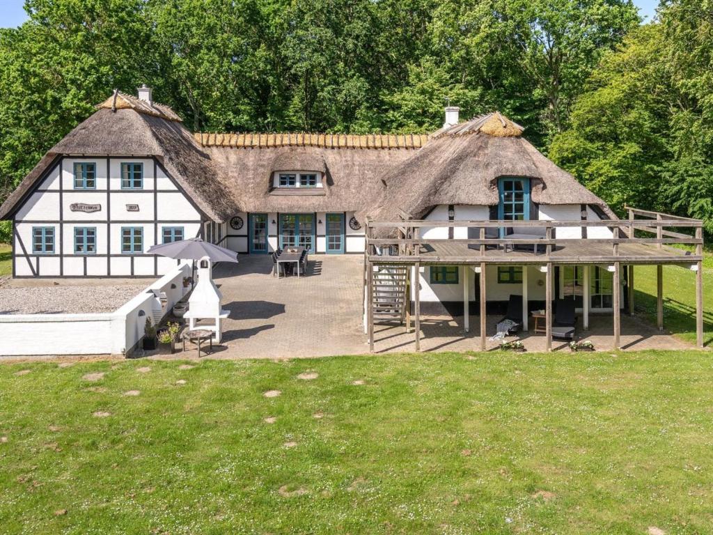 a large white house with a thatched roof at Holiday Home Sirkku - 320m from the sea by Interhome in Tranekær