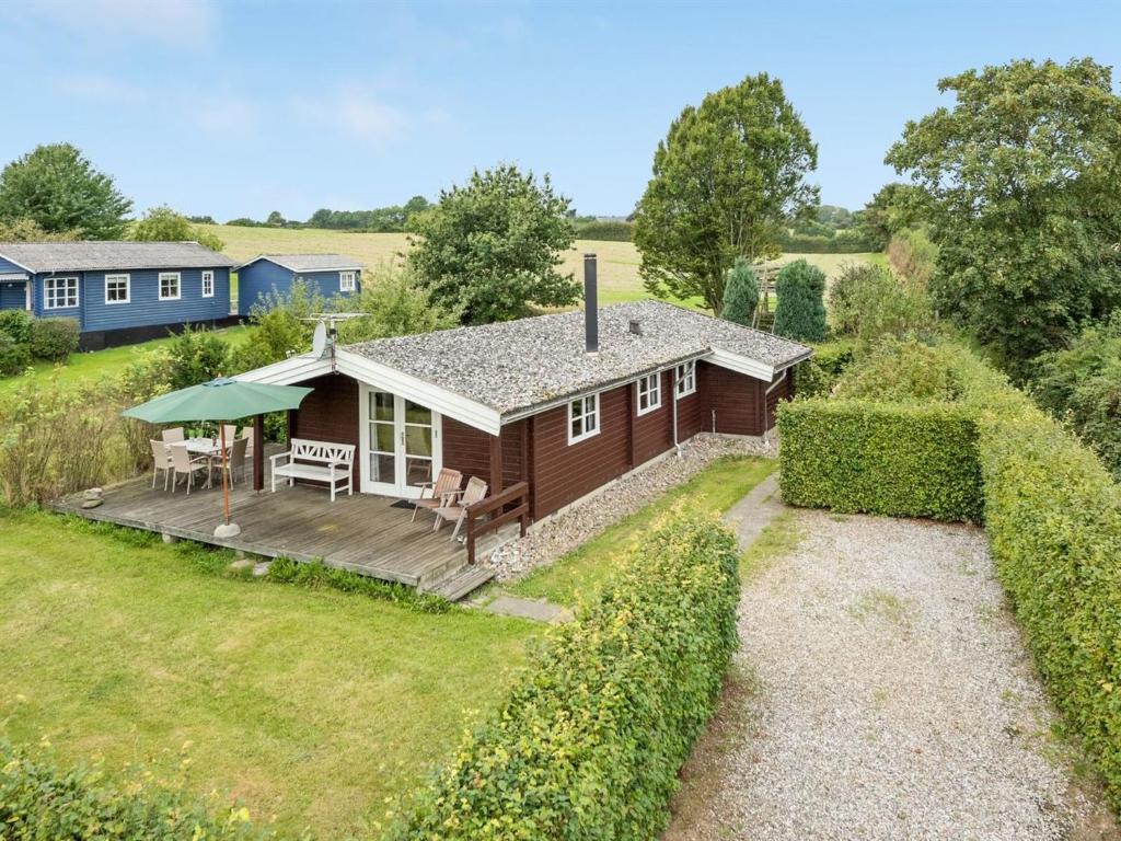a small house with a deck and a house at Holiday Home Gudmunde - 200m from the sea by Interhome in Augustenborg