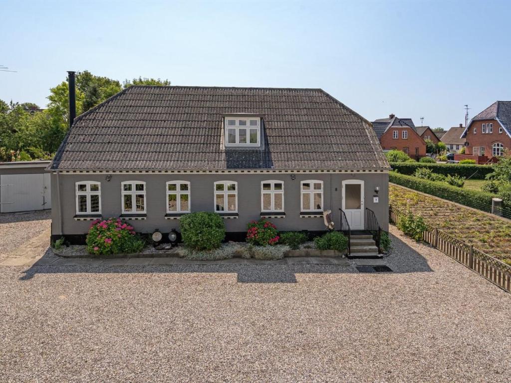a small house with a gray roof on a driveway at Holiday Home Evje - 250m from the sea by Interhome in Bagenkop
