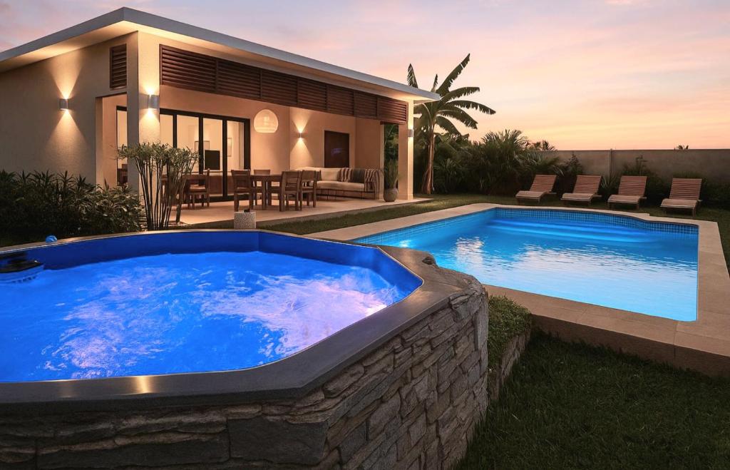 a large blue swimming pool in front of a house at Villa Solenzara - Private Luxury Residence Nosy Be in Nosy Be