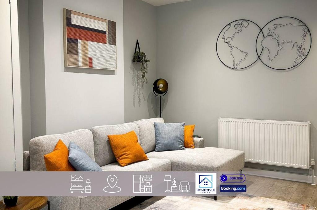 a living room with a gray couch with orange pillows at Spacious 4BDR House By Homestyles Hosts Short Lets & Serviced Accommodation Suffolk With Private En-Suite & Free Parking in Ipswich