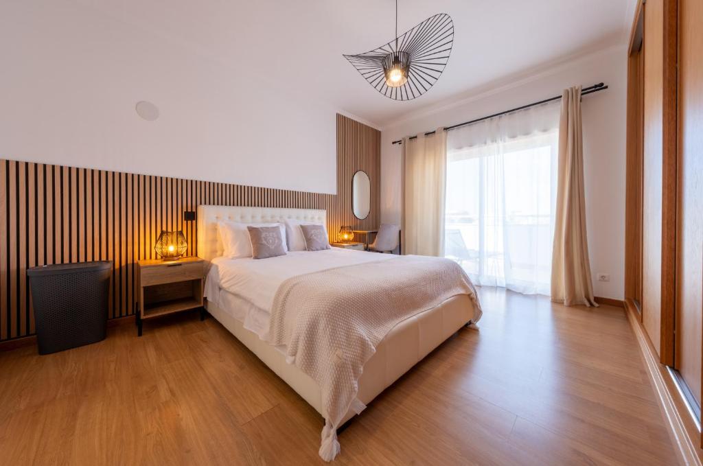 Villa Ofelia 46 by Destination Algarve في Santo Amaro: غرفة نوم بسرير كبير ونافذة كبيرة