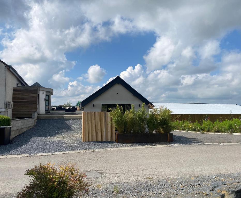 a house with a fence and some plants in a driveway at Gîte Meunier, tu dors in Vaux-sur-Sûre