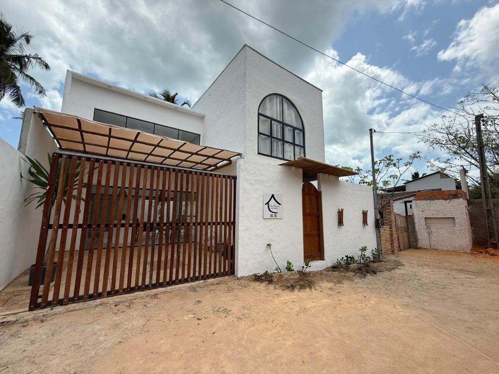 a white house with a gate in front of it at Casa Branca Mediterrânea in Barra Grande