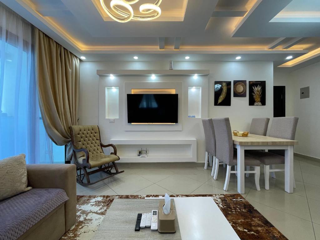 シャルム・エル・シェイクにあるSharm Hills Two bedrooms apartmentのソファと壁掛けテレビのあるリビングルーム