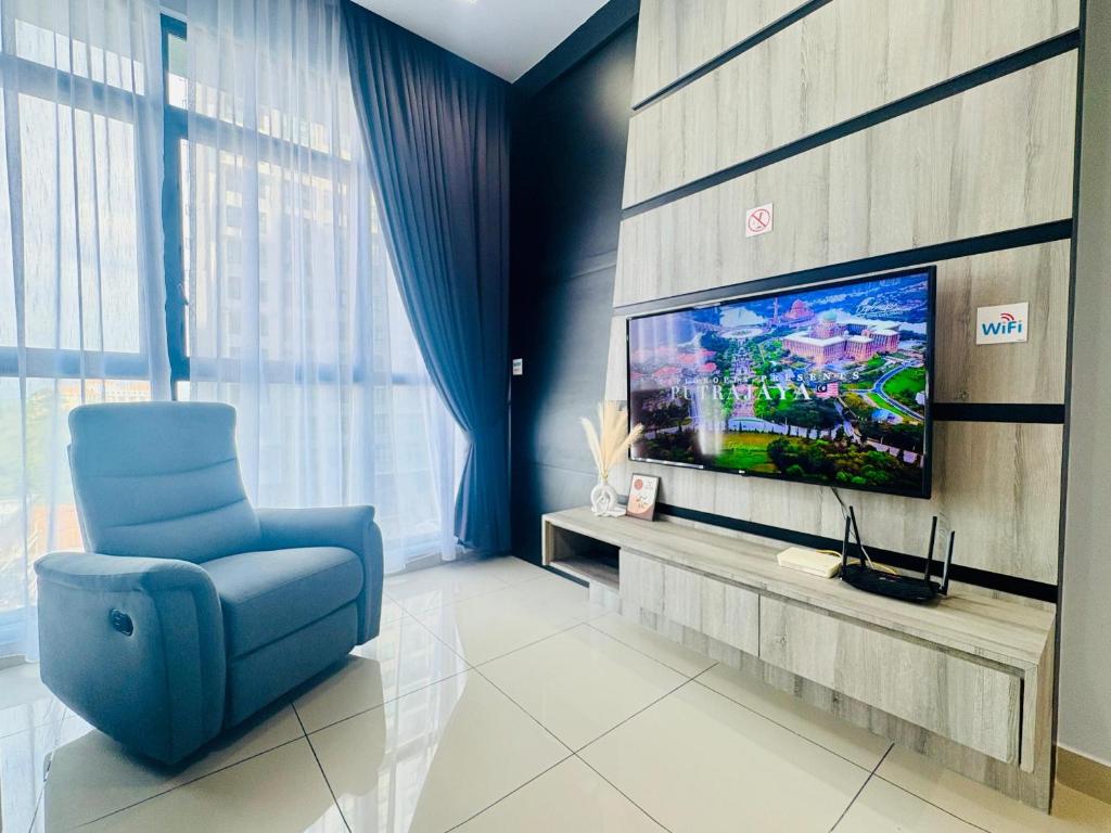 a living room with a blue chair and a tv at Group-Friendly Stay in Putrajaya & IOI City Mall in Putrajaya