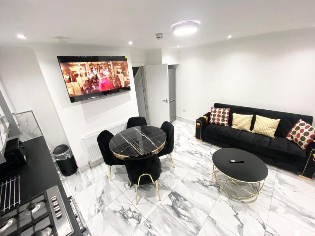a living room with a table and chairs and a couch at THE ROYAL BOUTIQUE MAYFAIR LODGE bY LONDON , SLEEP 8 in Hayes