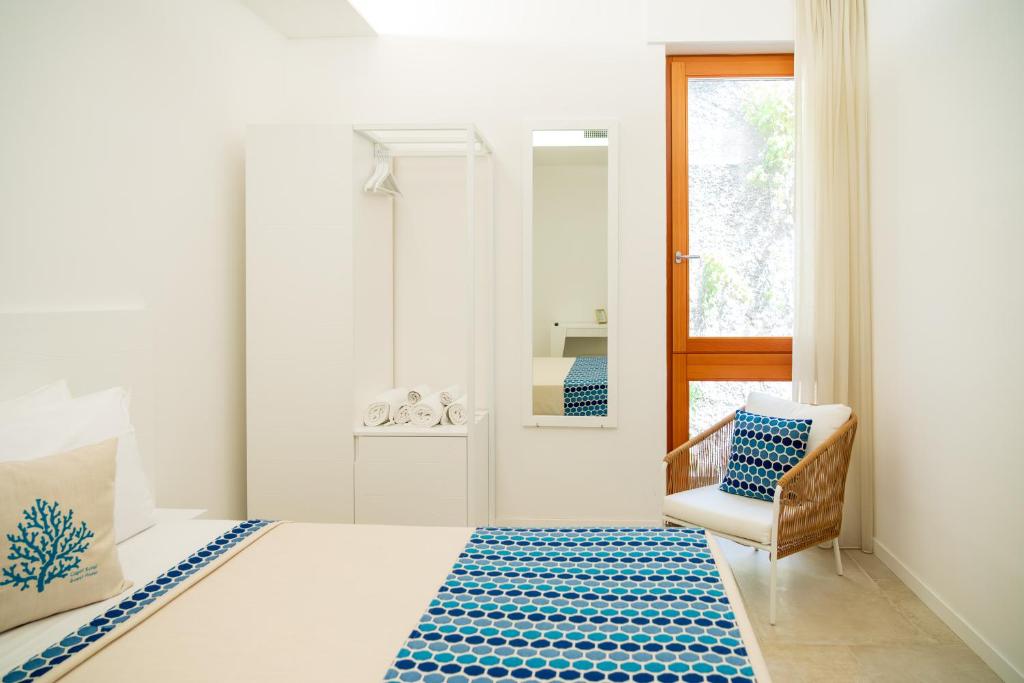 a bedroom with a bed and a chair and a mirror at Capri Koral Guest House in Capri