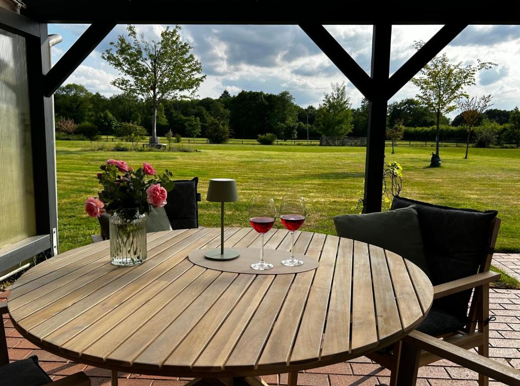 a wooden table with two glasses of wine at Ferienhaus Weidblick in Westerstede