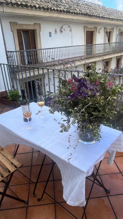 un tavolo con due bicchieri di vino e fiori sopra di Apartamento centrico, 5 bedrooms, 5 baños en-suite a Jerez de la Frontera