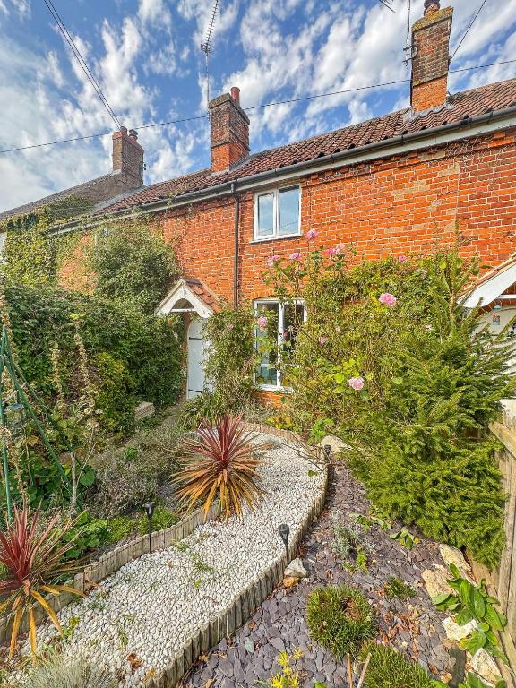 a brick house with a garden in front of it at Quaint 2 bed cottage near North Norfolk Coast - Harpers Cottages in Syderstone