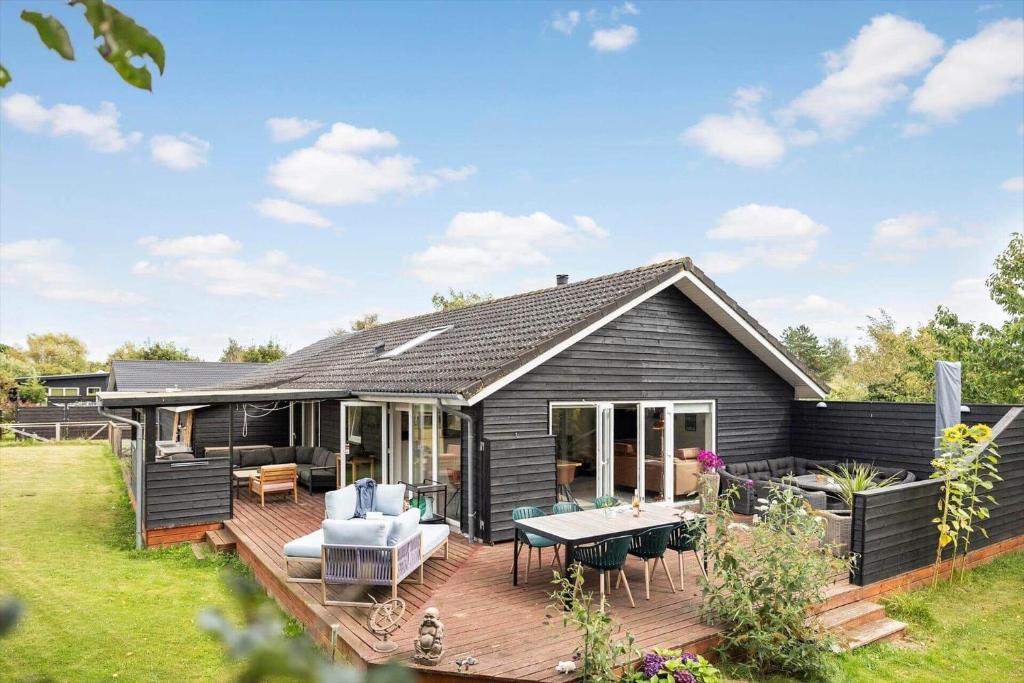 una casa nera con un ponte nel cortile di SL351-Korsor-Storkevej-48 a Tjæreby
