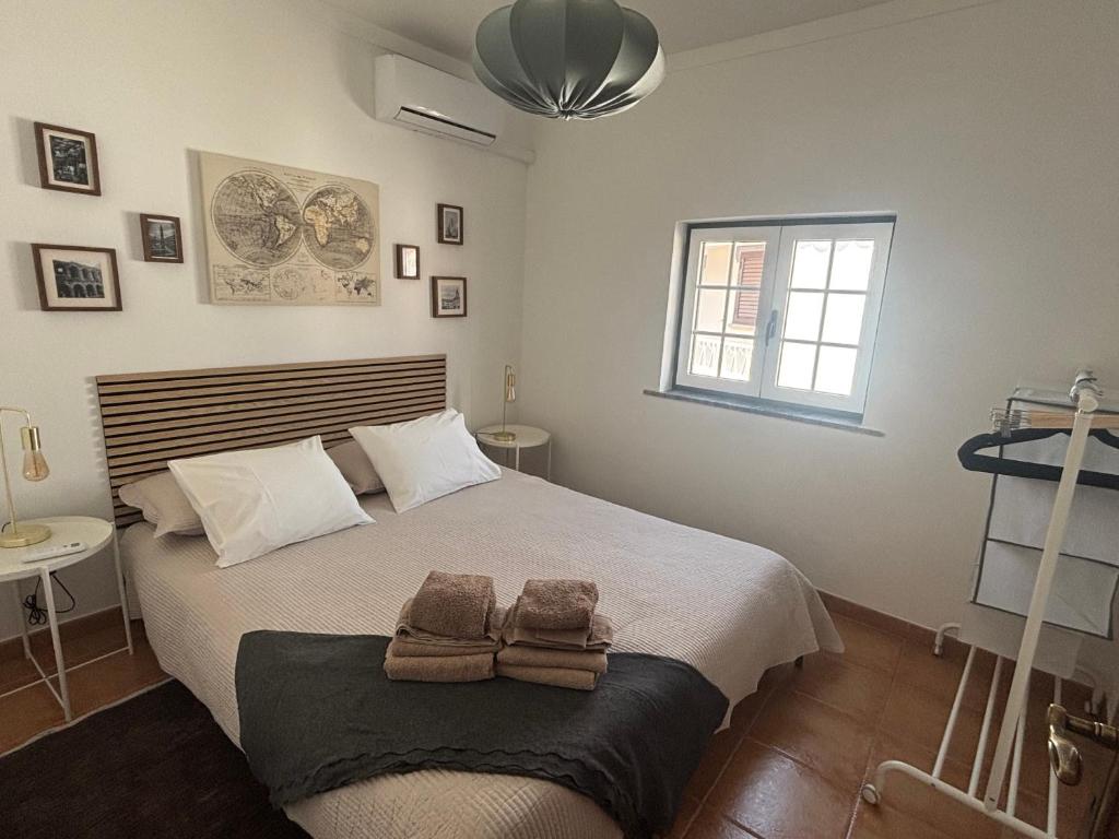 a bedroom with a large bed with towels on it at Casa D' Oliveira in Castro Verde