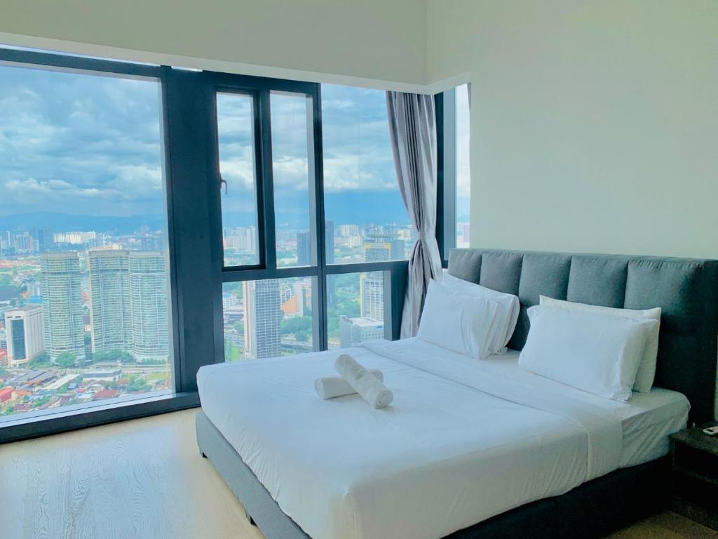 a bedroom with a white bed with a large window at STAR KLCC By Super Suites in Kuala Lumpur