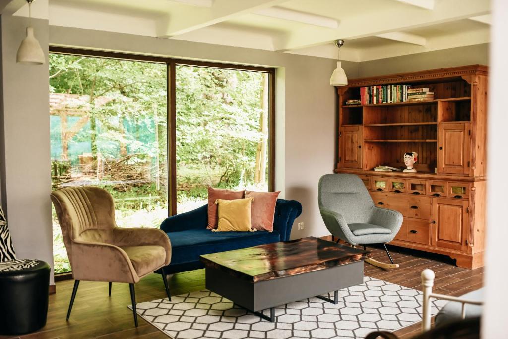 a living room with a blue couch and two chairs at Uroczysko Oleśnica in Chodzież