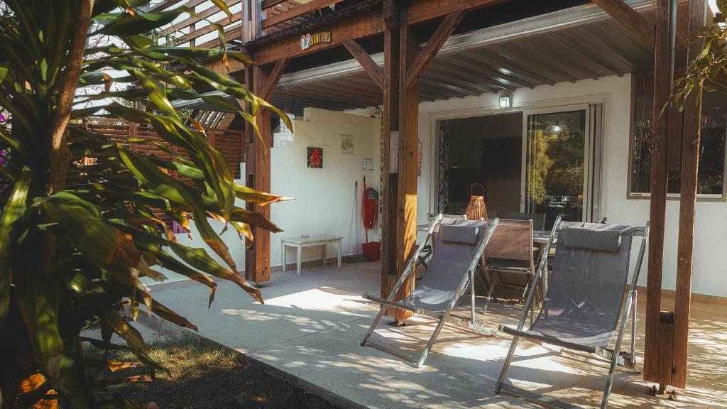 a patio with chairs and a table in a house at Appart. VANILLE T3 en RDJ proche du lagon in Saint-Gilles les Bains
