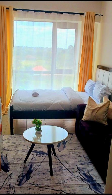a living room with a bed and a coffee table at Bellora Urban Homes in Ongata Rongai 