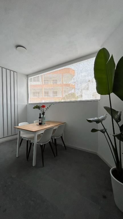 a dining room with a table and a potted plant at BeachVibe in Puerto Naos