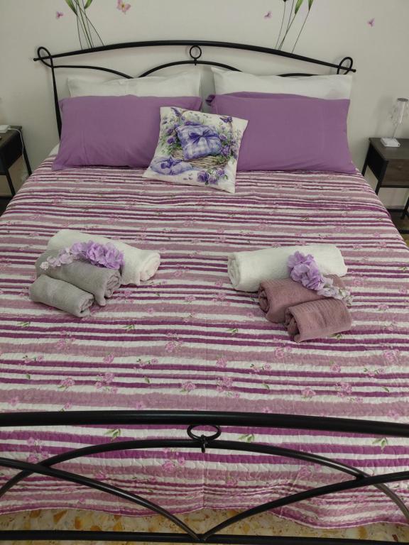 Una cama con almohadas moradas y moradas. en Casa di Lety Holiday House, en Civitavecchia