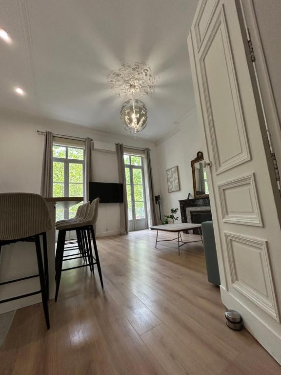 a living room with a door and a table and chairs at Appartement Avenue Feuchères Arènes in Nîmes