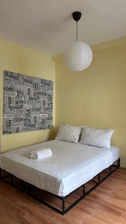 a bed in a room with a painting on the wall at Centrally Located Affordable Apartment with Kitchen in Boracay