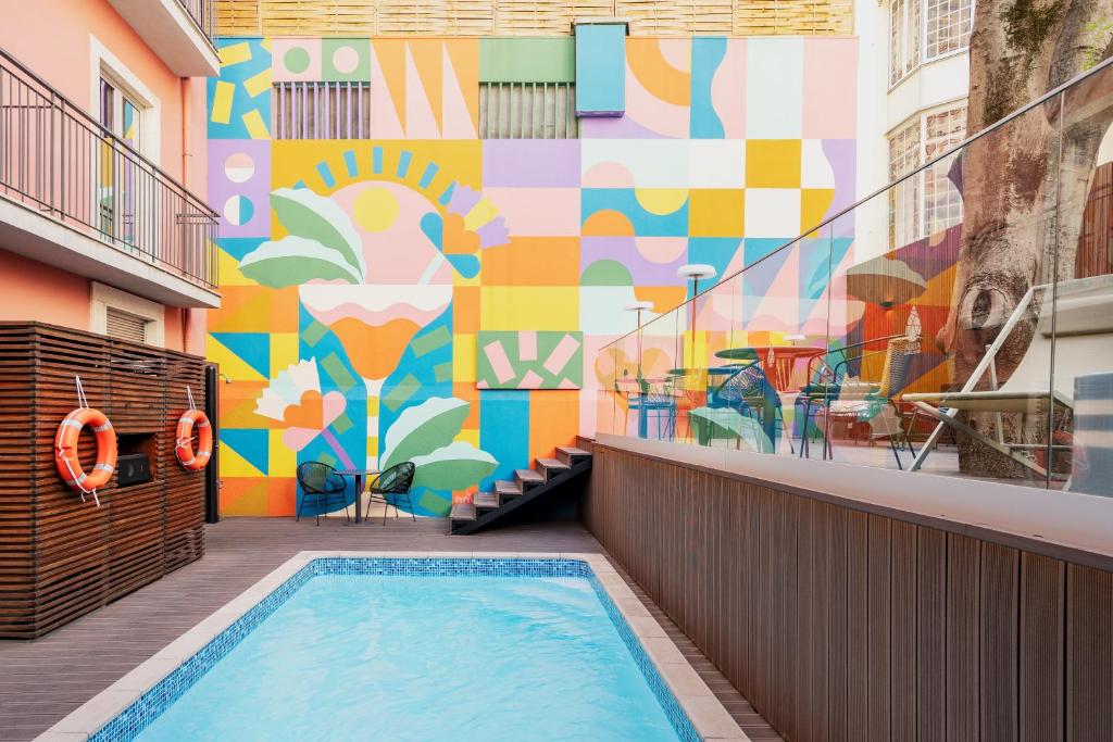 A small courtyard pool framed by a colourful geometric mural.