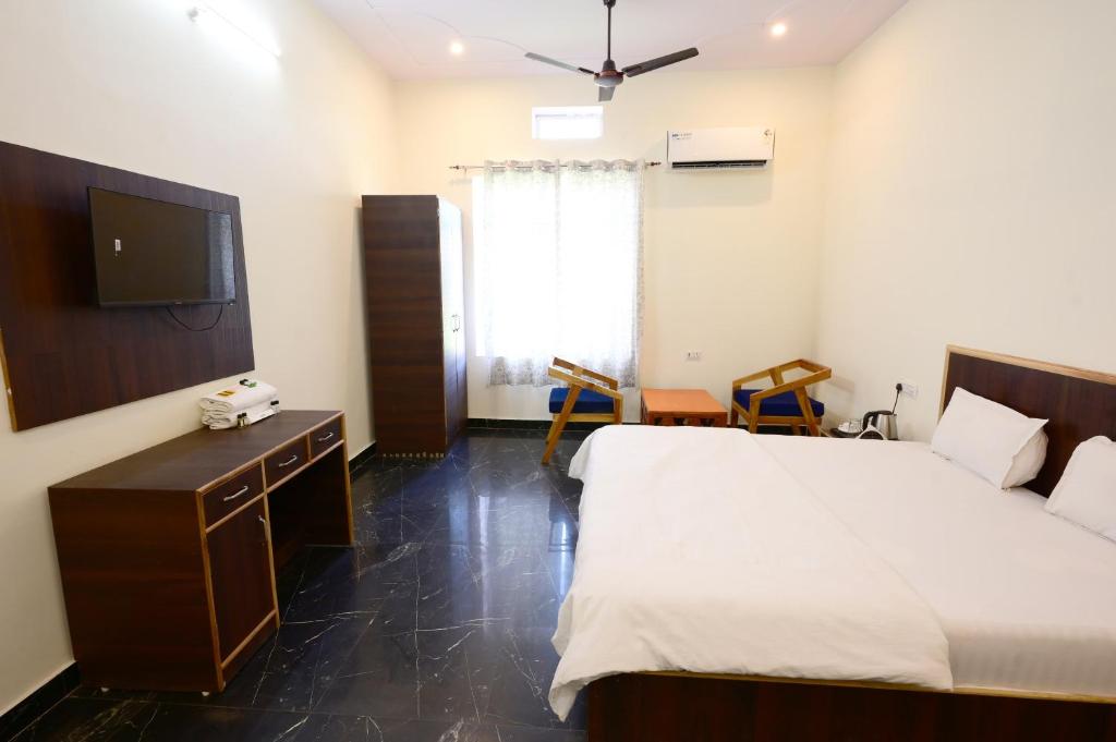 una habitación de hotel con una cama y un televisor en Ranthambore Sawai Palace, en Sawāi Mādhopur