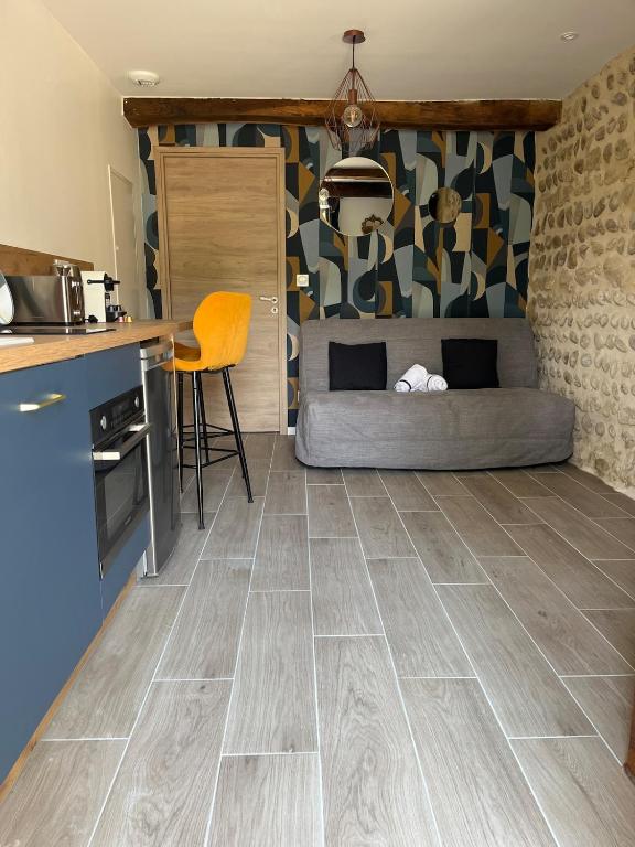 a room with a bed and a kitchen with a tile floor at La Source Bleue in Le Chalon