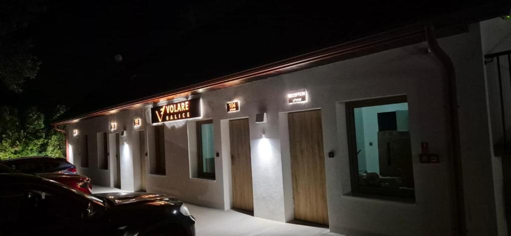 a sign on the side of a building at night at Volare Balice in Cholerzyn