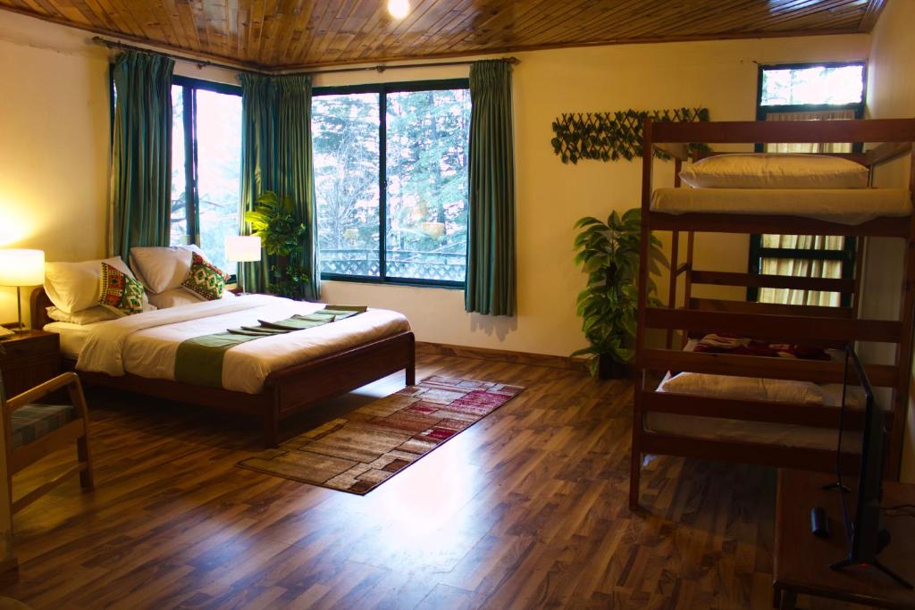 a bedroom with a bed and a bunk bed at Umda Hotel Montana in Nathia Gali