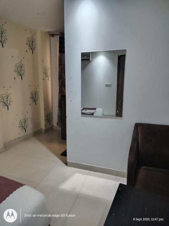 a living room with a mirror and a couch at Hotel Banke Bihari Stays in Vrindāvan