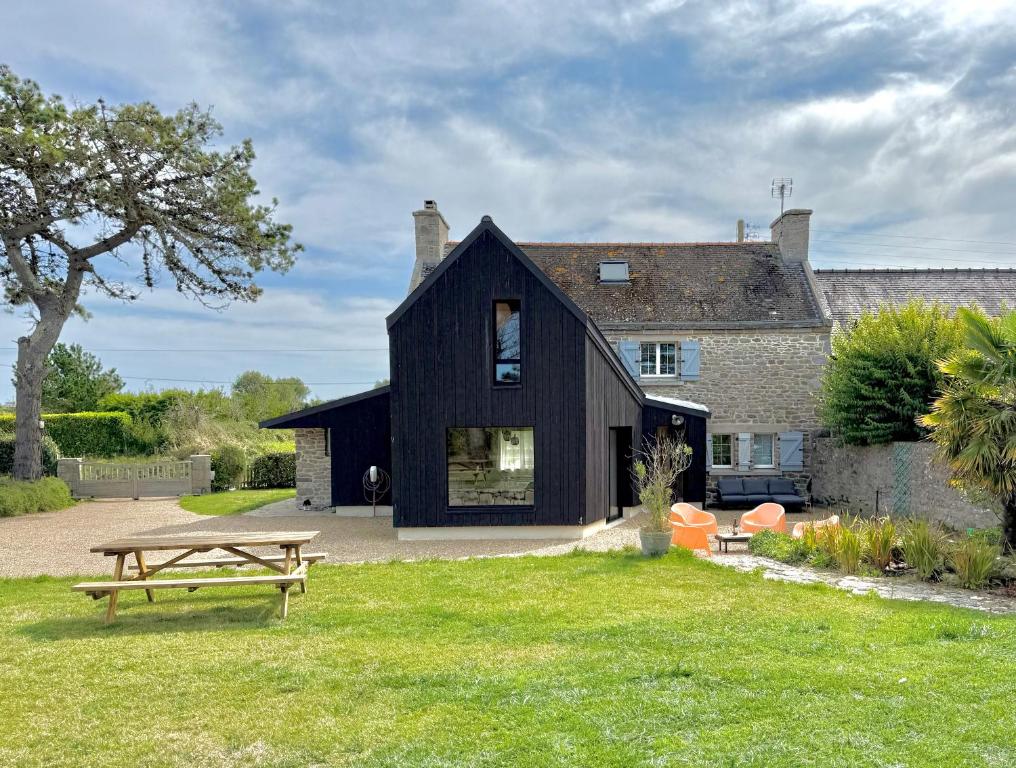 ein schwarzes Haus mit einem Picknicktisch davor in der Unterkunft MEZKOLE - Maison de vacances familiale à Plouguerneau 10 personnes, jardin, proche plages in Plouguerneau