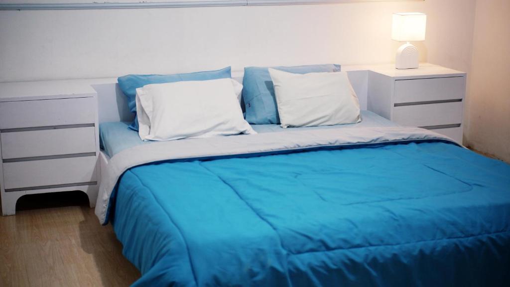 a bed with blue sheets and white pillows in a bedroom at Pondok Kalimaya in Serang