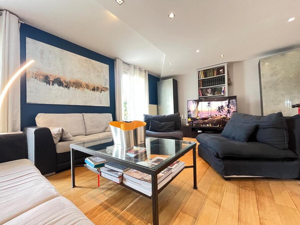 a living room with a couch and a table at Les hauts de Merfy maison 5 chambres avec piscine 
