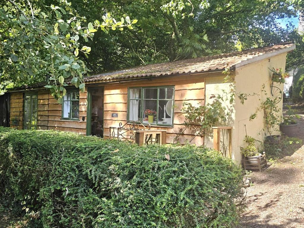 a small house with a window on the side of it at Bluebell Cottage At Lurley Manor in Washfield