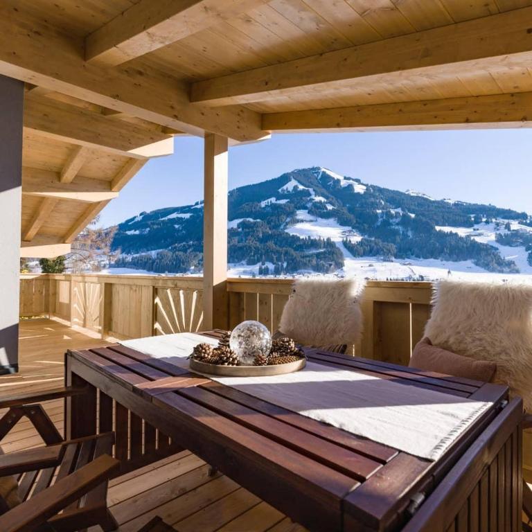 a table on a deck with a view of a mountain at Appartements Morgensonne in Westendorf