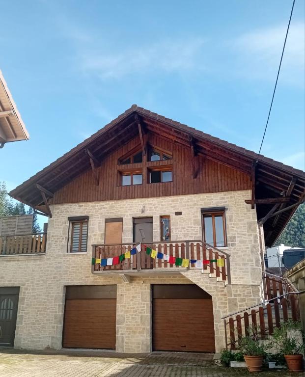 a house with a balcony with flags on it at La Vie en Rose et Azur in Cluses